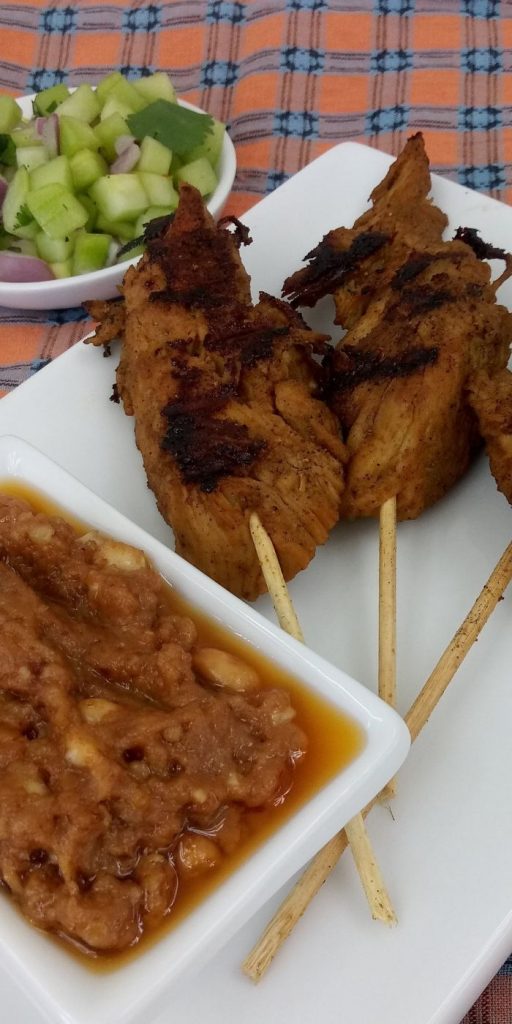 homemade cucumber satay on a plate with peanut sauce by it