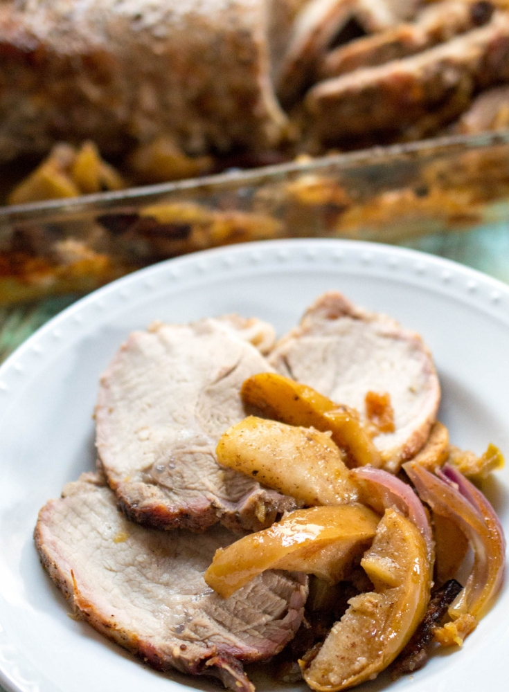 a roasted pork loin with apples served on plate